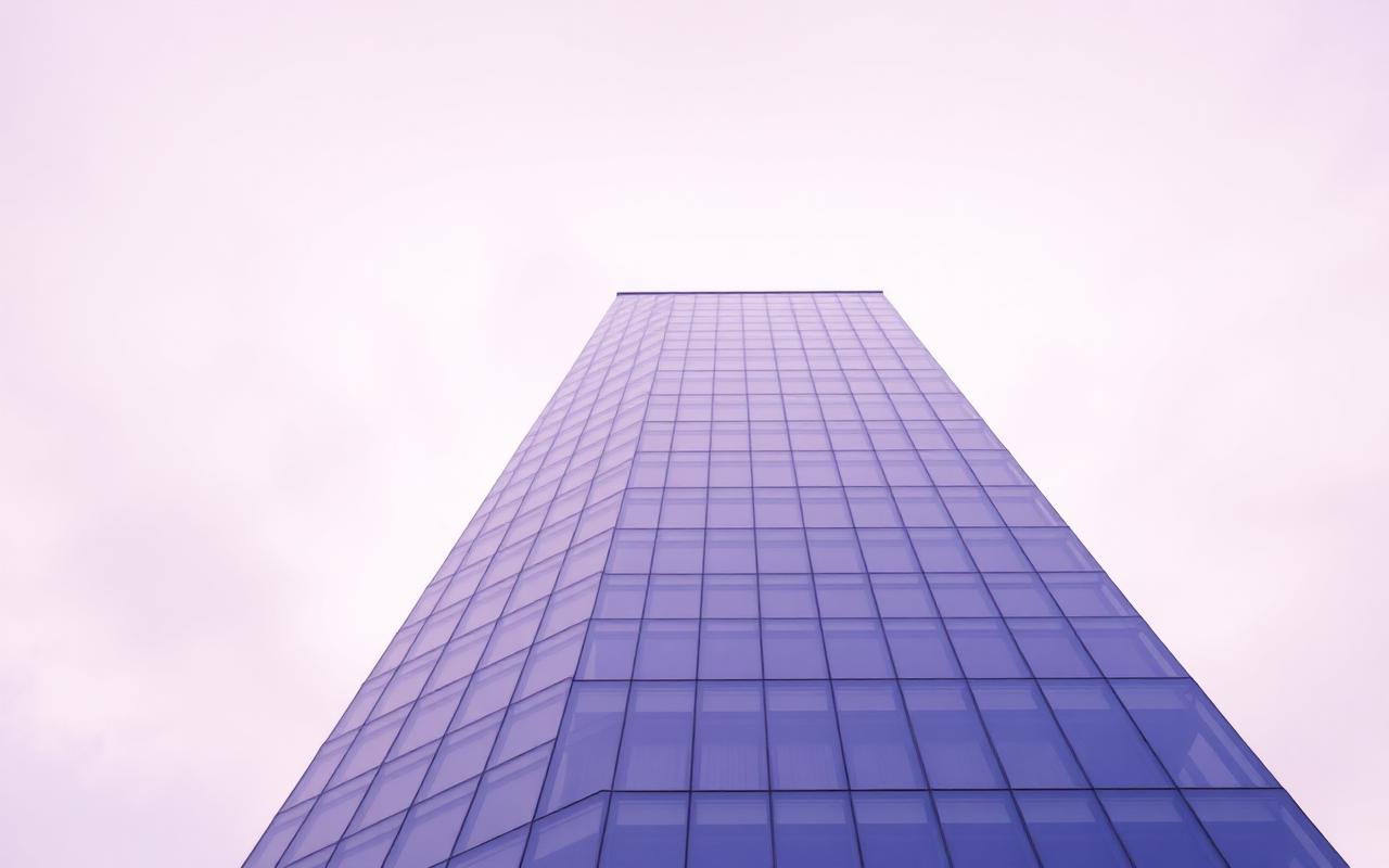 A pale glass tower photographed from below against a soft lilac sky